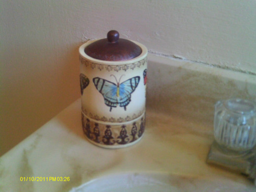A butterfly candle holder accents the sink area and coordinates with the butterfly theme
