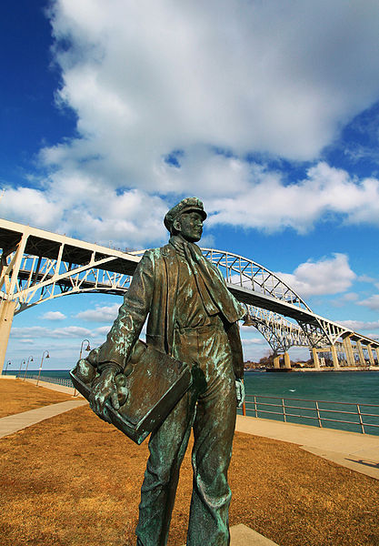A statue of a young Thomas Edison in front of the Blue Water Bridge, Port Huron, Michigan.