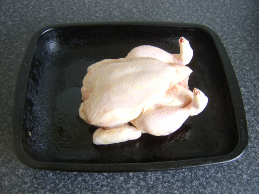 Whole chicken is laid on lightly oiled roasting tray