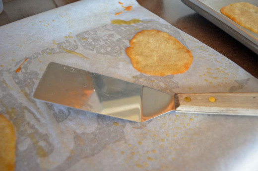 Lift parchment paper off pan and then lift cookie off parchment with metal flat spatula.