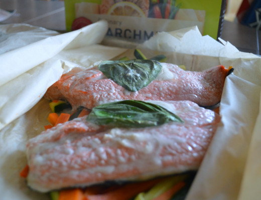 Salmon with lemon sauce and basil cooked in parchment bags.