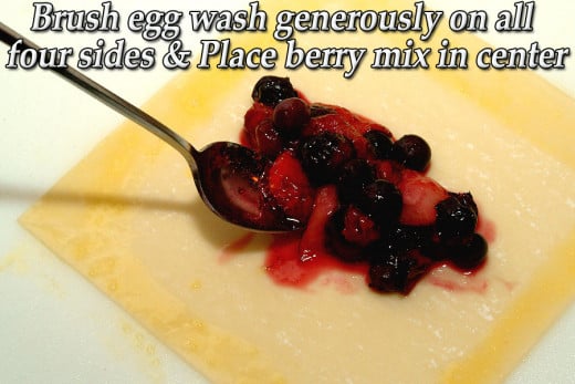  Brush a 1" wide strip of egg wash on all four sides. Fill with the drained berry mix.