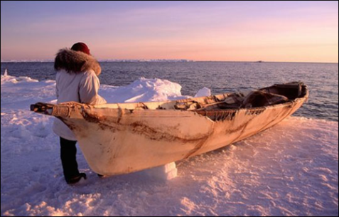 An Inupiat person preparing to launch a boat in an area that typically would have been frozen in that time of year.