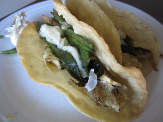 Home fried tacos with scrambled eggs, roasted poblano chiles, caramelized onions and melting brie. 