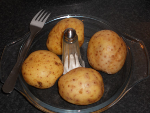 You need to start by preparing your potatoes. Wash them thoroughly, prick several times with a fork and then salt the skin. Place in an oven for 1 hour at 200C