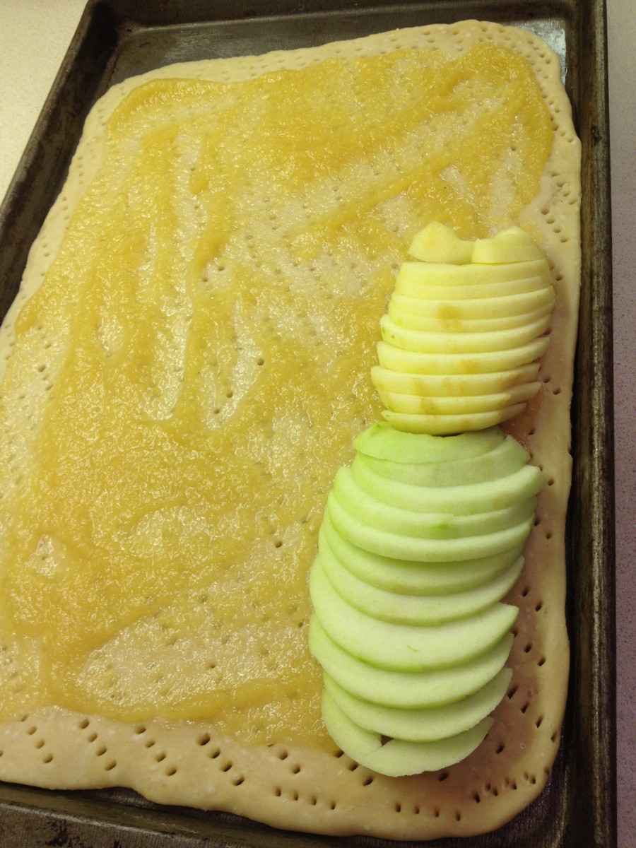 Pour applesauce onto dough, spread evenly; arrange apples on top down the length of the dough. 