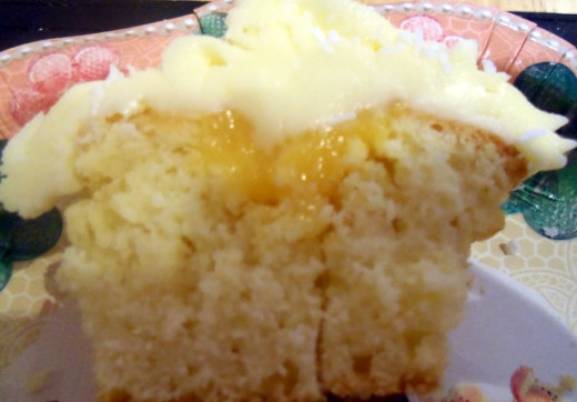 Fill the cupcake with lemon curd or lemon sauce and ice with buttercream frosting.