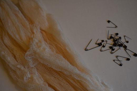 Cheesecloth (dyed with tea) and safety pins