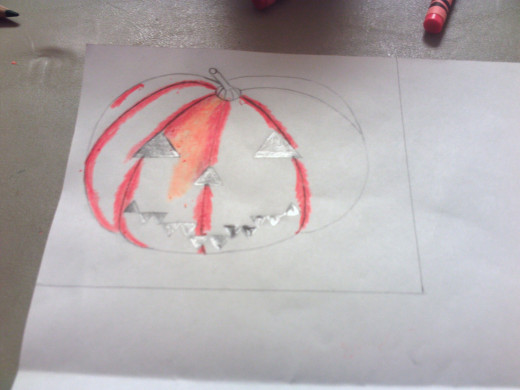 Start coloring in the pumpkin with a red-orange and a lighter orange colored pencils.