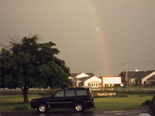 Rainbow by the street sign