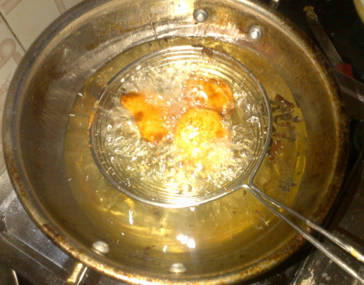 Gram flour dipped Potatoes getting fried in the oil