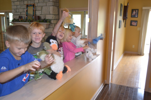 Kids using stuffed animals for a puppet show