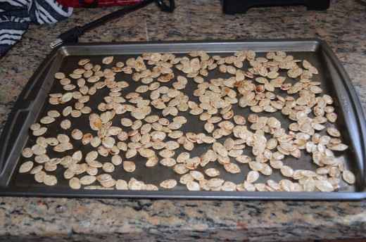 Pumpkin seeds spread on cookie sheet