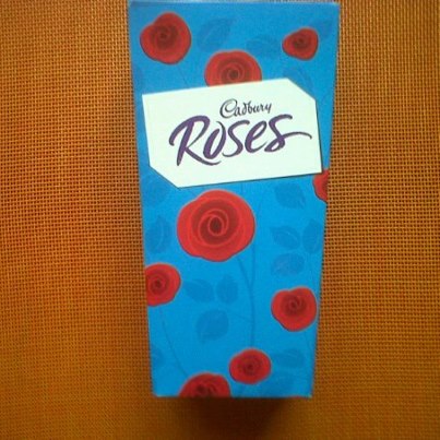 Cadbury Roses come in a distinctive blue box with pictures of red roses.