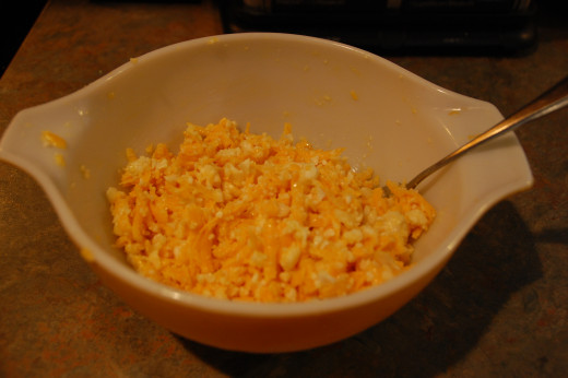 Mixing the egg, riced cauliflower and cheddar cheese together