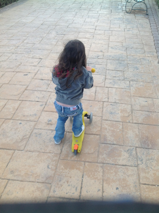 Riding her yellow Mini Micro Scooter and loving it!