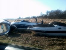 THERE ARE SO MANY BIG AND SMALL BOATS WASHED INTO THE MARSHLANDS.  THEY ARE EVEN IN THE WOODS TO THE RIGHT OF PHOTO.