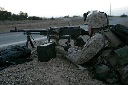 A U.S. Marine from Weapons Platoon, Company E, 2nd Battalion, 1st Marine Regiment, 1st Marine Division, mans an M240G machine gun at the Highway 1 "cloverleaf" outside the city of Fallujah, Iraq, April 5, 2004. U.S. Marines islolated the city after t