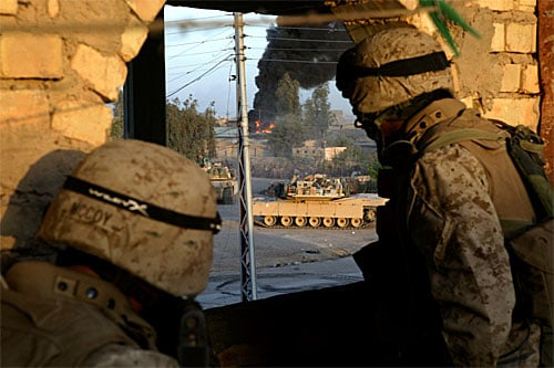 Marines of 1st Marine Regiment in Fallujah. Infantrymen from 1st Platoon, Company E, 2nd Battalion, 1st Marine Regiment, 1st Marine Division, look on from a rooftop as M-1A1 tanks from 1st Tank Battalion fire on buildings where enemy snipers took pos