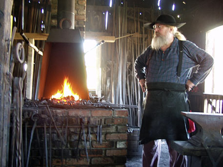 Blacksmith, always warm inside this building as he keeps the fire going.