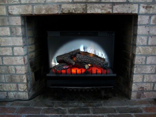 The insert is sitting on top of a fireplace grill, so that it is centered in the space.
