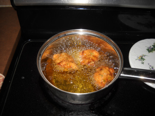 Frying fritters in pot of oil
