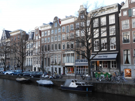 A street in Amsterdam bordered by a canal.