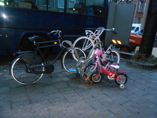This looks like the family bike rack. There's a Dad's bike, a mom's bike and 2 kids bikes all on this one rack in a residential area.