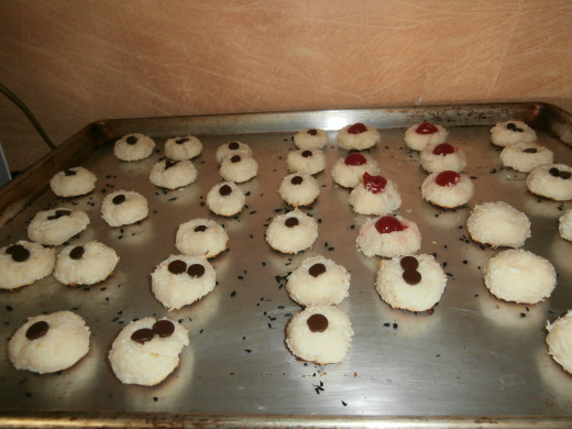 As soon as the cookies come out of the oven insert chocolate chips, cherry halves, or leave plain as is. 