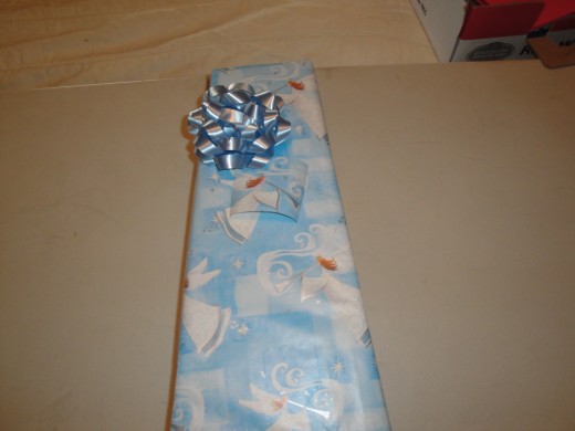 Add bow and name tag.  I do not recommend putting ribbons on packages like this one, as the ribbon will slide around (unless you use a lot of tape) and possibly rip your paper.