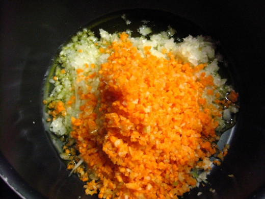 Add the minced carrots and celery, a cup of water, and let cook. Cook over medium heat until softer, for about 10 minutes.