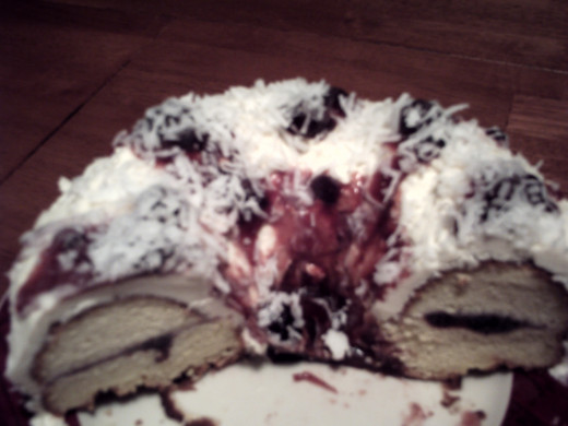 12. Organic Blueberry syrup mixed with real blueberries and preserves filled in the middle and dribbled over white confectioners sugar icing made with butter and the flaked with cocoanut-always in the cupboard for Mr. Cocoanut Lover.
