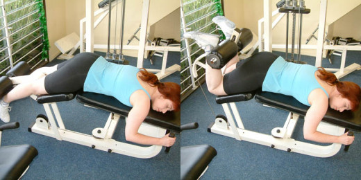 Woman demonstrating leg curl machine at a gym.