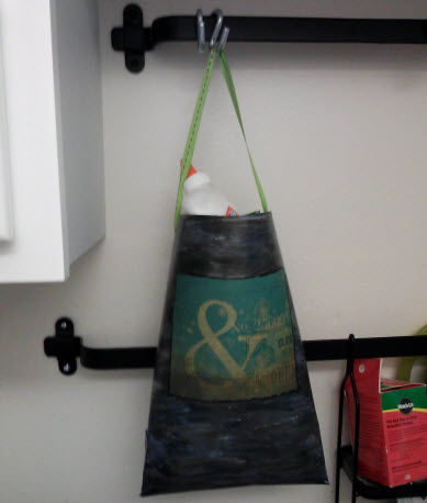 Hanging paperbucket holding my binding materials such as the glue sticking out. It is such a time saver to be able to just grab the bucket when working on projects