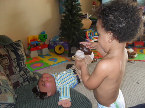 My son dressing his baby doll