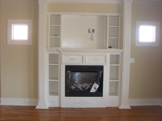 When this all electric house was renovated, a fireplace with shelving and detailed woodwork was added.