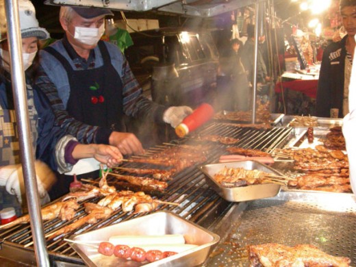A mobile vendor seasons his Japanese BBQ in Taiwan