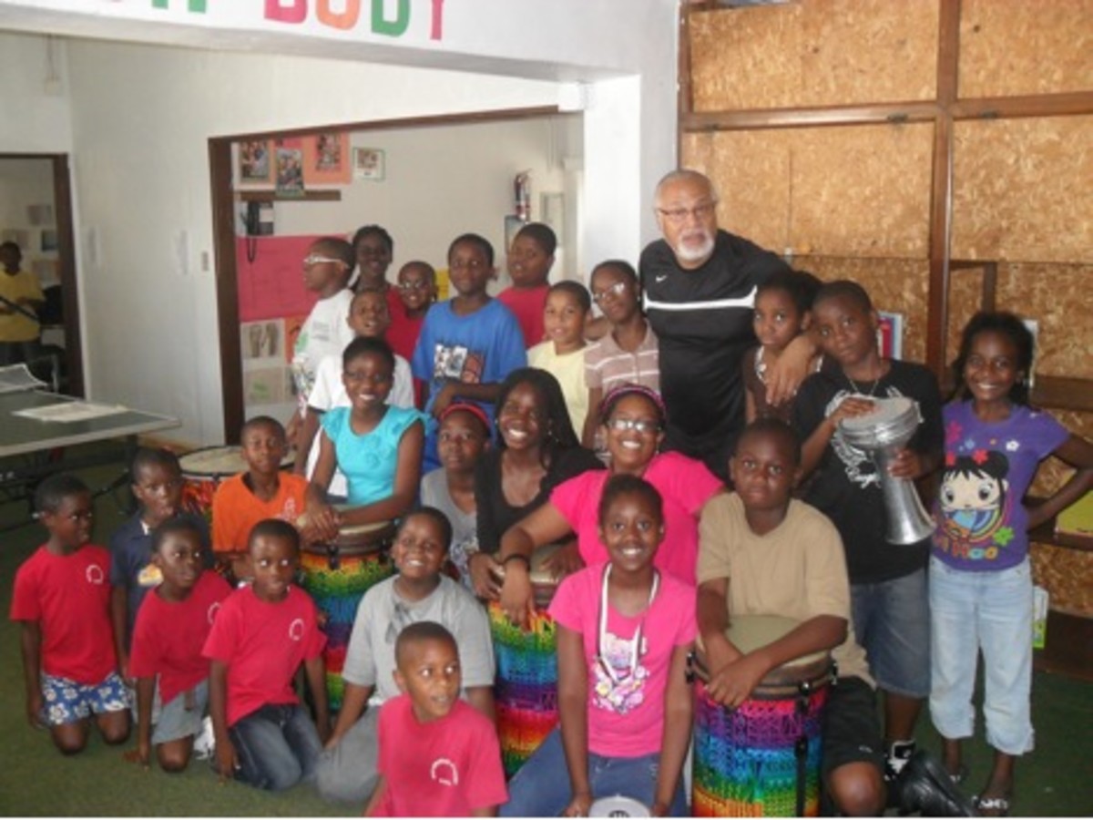 Los estudiantes New Mirawood Academy posan con Willie después de una lección de su Programa de Música Rhythm of Africa, que tiene como objetivo crear un impacto conductual y cognitivo positivo a través de la exposición e intimidad de los niños a aprender y hacer música.