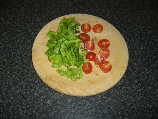 Lettuce is shredded and cherry tomatoes are halved