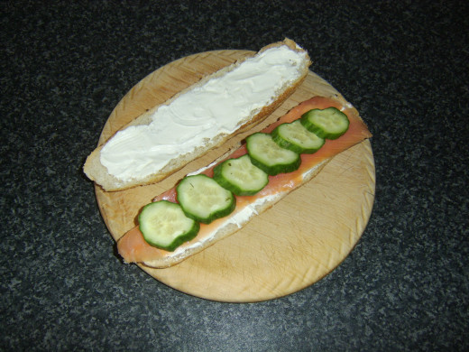 Pickled cucumber is laid on smoked salmon