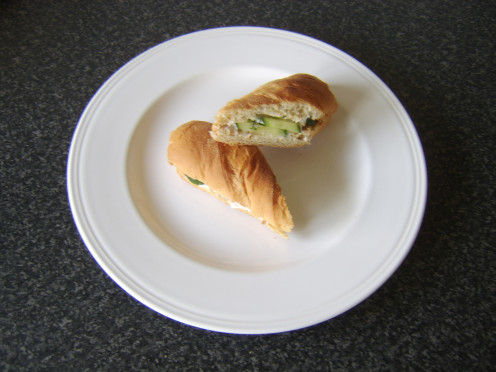 Mayo is spread on both halves of a toasted sub before cucmber and freshly chopped is added