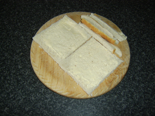 Crusts are cut from lightly buttered bread
