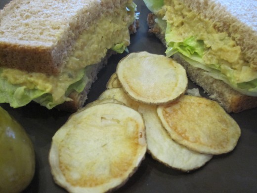 Mock tuna sandwich, homemade potato chips, and a pickle