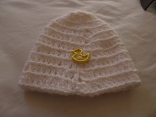 White beanie cap with duck button sewn along bottom half. You can sew on where ever you like