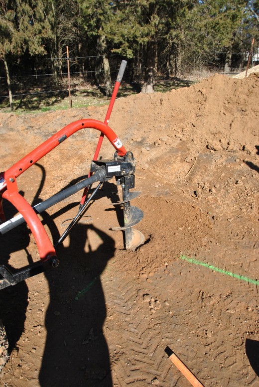 Post hole auger operated by 3 point hitch on John Deere Tractor