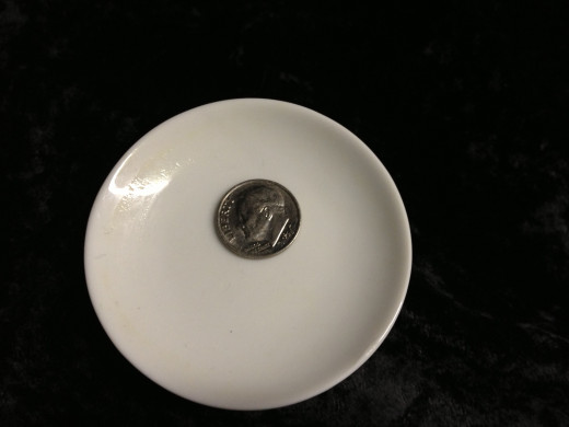 Small porcelain plate used as a teabag rest- I placed a dime on it to give a size comparison