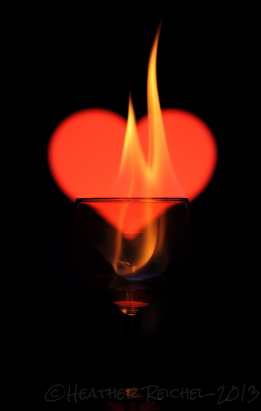 Flames photographed in a wine glass with a iPad running the app Soft box Symbols in the background