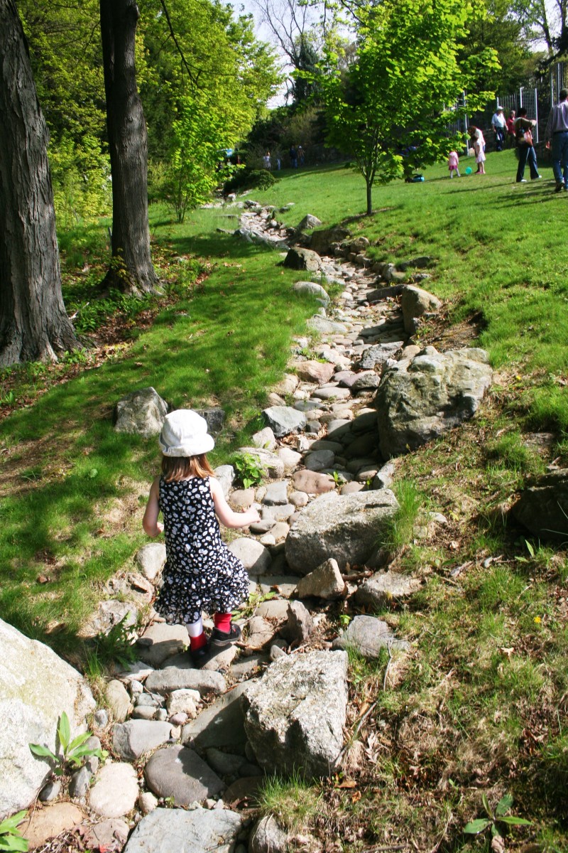 Our daughter walking down a stone path in the middle of an arboretum