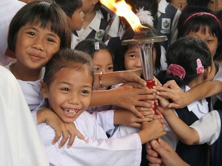 children smiling with the Peace Torch