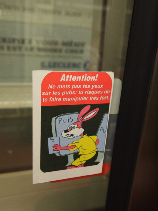 This is a parody of the famous "RATP Bunny", RATP being the Parisian authority for transports. The original texts warns children from trapping their hands between the doors, this one warns us all from manipulative advertisements.